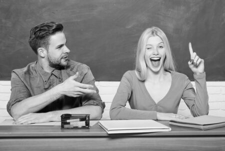 Couple friends students studying university. Enjoying university life. Guy and girl sit at desk in classroom. Correct answer on their mind. Studying in college or university. Apply for free programの写真素材