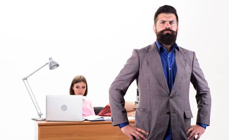 Feeling confident. Confident businessman and female coworker in office. Confident caucasian man with pretty woman working in background. Confident boss with long beard in formal wearの写真素材