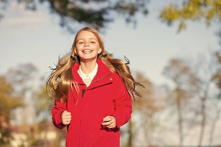 Full of life energy. Child cheerful on fall walk. Warm coat best choice for autumn. Autumn outfit concept. Kid girl wear coat for autumn season nature background. Keep body warm clothes autumn daysの写真素材