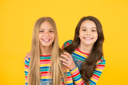 Long hair best female adorn. Girls blonde and brunette shiny healthy hair. Hair strengthening. Grow hair. Hairdresser salon. Kids beautiful friends or sisters with perfect hairstyles. Natural beautyの写真素材