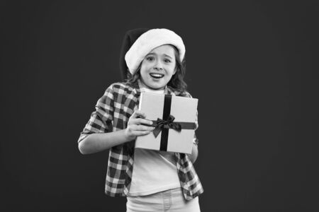 Happy winter holidays. Being surprised. Small girl. New year party. Santa claus kid. Christmas shopping. Present for Xmas. Childhood. Little girl child in santa red hat. wow.の写真素材