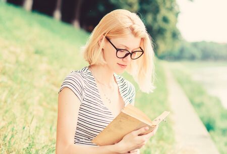 inspired by novel author. interesting story. Relax and get new information. woman in park reading book. reading is my hobby. Summer study. student girl with book outdoor. holding lesson bookの写真素材