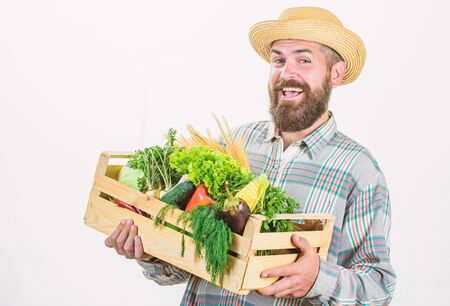 Locally grown foods. Farmer lifestyle professional occupation. Buy local foods. Farmer rustic bearded man hold wooden box with homegrown vegetables white background. Farmer guy carry harvestの写真素材