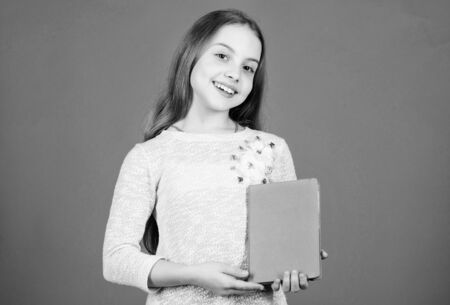 Shes a student of language and literature. Cute little child holding book in English literature. Adorable small girl reading literature book. Fiction and scientific literature, copy spaceの写真素材