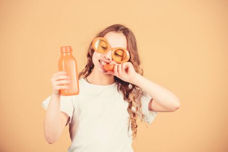 Fashion kid sunglasses drink refreshing vitamin juice. Health care. Summer vitamin diet. Happy childhood. Natural vitamin source. Girl eat carrot vegetable and drink carrot juice. Vitamin nutritionの写真素材