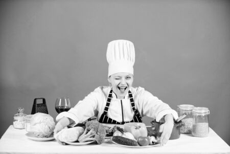 Woman chef wear hat apron near table ingredients. Girl adorable chef teach culinary. Best culinary recipes to try at home. Homemade food tips. Turn ingredients into delicious meal. Culinary skillsの写真素材