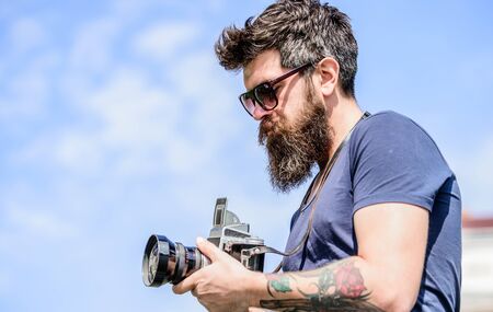 Content creator. Man bearded hipster photographer. Old but still good. Manual settings. Photographer hold vintage camera. Modern blogger. Photographer with beard and mustache. Man shooting photosの写真素材