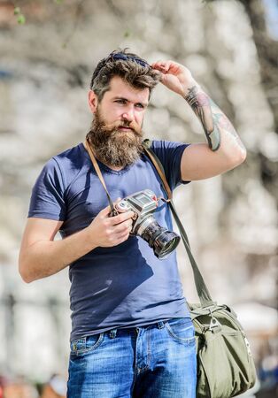Mature hipster with beard. Bearded man. photo of nature. reporter or journalist. brutal photographer with camera. retro photographic equipment. Photo equipment. hipster man in summer sunglassesの写真素材