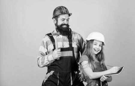 Kid girl planning renovation. Child renovation room. Family remodeling house. Home remodel and renovation. Father and daughter hard hat helmet uniform renovating home. Home improvement activityの写真素材