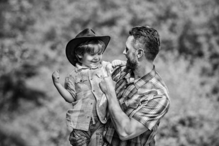 Spirit of adventures. Strong like father. Power being father. Child having fun cowboy dad. Rustic family. Growing cute cowboy. Small helper in garden. Little boy and father in nature backgroundの写真素材