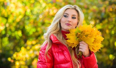 Woman spend pleasant time in autumnal park. Lady posing with leaves autumnal nature background....