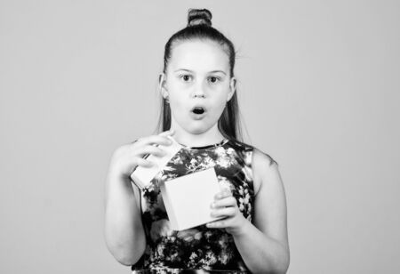surprised child. Little girl with gift. Small girl with present box. Surprise. Childrens day. Congratulation. Happy birthday. Holiday celebration. Boxing day. Christmas shopping. This is for youの写真素材