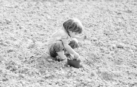 happy child gardener. botanic worker. Spring. earth day. new life. summer farm. small kid planting a flower. ecology life. Cultivation concept. farming and agriculture. I love to work with flowersの写真素材
