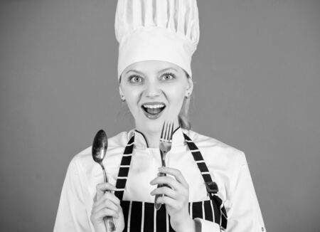 Offering you utensils to eat. Professional cook of culinary school. Woman chef holding stainless steel spoon and fork. Culinary arts academy. Culinary skills. Traditional culinaryの写真素材