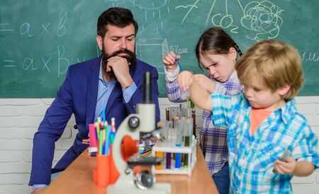 Experimenting together. Kids adorable friends having fun in school. School chemistry lab concept. Supportive environment explore STEM. Practical knowledge. Child care and development. School classesの写真素材