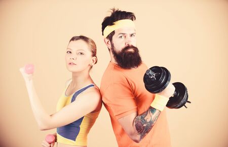 Sporty family. Healthy lifestyle concept. Man and woman exercising with dumbbells. Fitness exercises with dumbbells. Workout with dumbbells. Girl and guy hold dumbbells. Fitness sport exercisesの写真素材