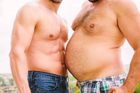 Turn beer belly into six packs abs in easy steps. Weight loss. Sport motivation. Get ready summer body. Compare fat and six packs attractive torso. Male ugly fat belly and strong six packs musclesの写真素材