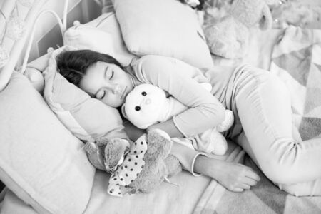 little child girl with xmas present. happy new year. Christmas shopping. waiting for santa. Winter. small girl sleeping at home. christmas family holiday. morning before Xmas. Sleep. its christmasの写真素材