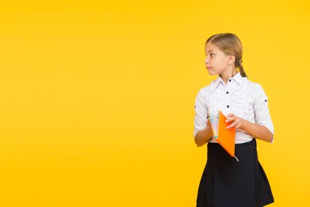 A moments of reading the best. Adorable little girl holding reading book on yellow background. Cute small schoolchild learn reading at primary school. A reading is non stop fun, copy spaceの写真素材