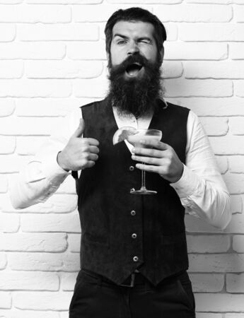 Handsome bearded man with long beard and mustache has stylish hair on funny faceの写真素材