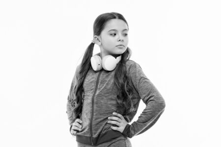 Immersing in music. Adorable headset user isolated on white. Small child wearing adjustable white headset. Little girl with wireless  headset. Cute kid with stereo headset to music listening.の写真素材