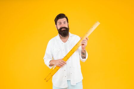 School teacher with ruler teaching geometry on yellow