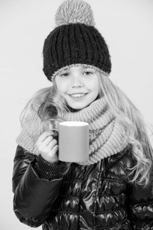 Girl in hat, pink scarf, black jacket with mugの写真素材