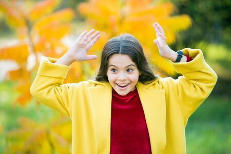 Child cheerful on fall walk. Warm coat best choice for autumn. Autumn season concept. Kid girl wear coat for autumn weather nature background. Fun activities for warm autumn days. Fall bucket listの写真素材