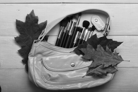 osmetic bag in yellow color on light wooden background.の写真素材