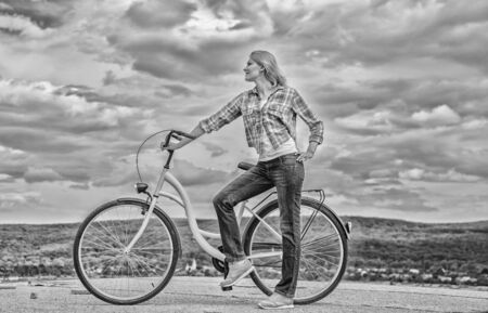 Girl ride cruiser bicycle. Health benefits of cycling. Reasons to ride bike. Woman rides bicycle sky...