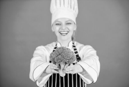 Eat healthy. Girl wear hat and apron hold vegetable. Healthy ration. Woman professional chef hold raw broccoli vegetable. Free healthy vegetarian and vegan recipes. Healthy raw food. Dieting conceptの写真素材