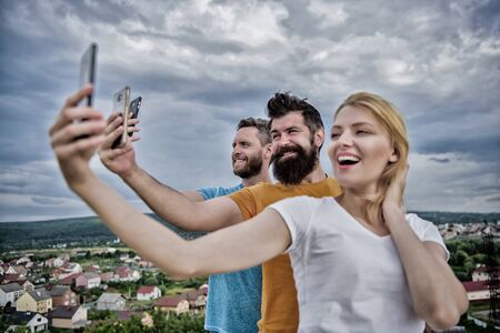 Girl and man with mobile smartphones communication online. Selfie time. Life online. People taking selfie or streaming video. Mobile internet social networks. Mobile dependency problem. Bloggers teamの写真素材