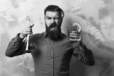 Brutal hipster holding alcoholic shot and glass tube or flaskの写真素材