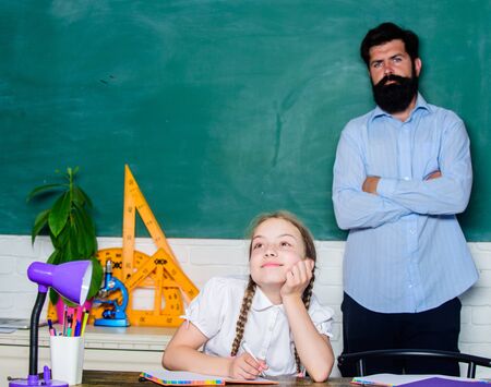 dreaming girl. back to school. education child development. knowledge day. Home schooling. daughter study with father. Teachers day. bearded man teacher with small girl in classroomの写真素材