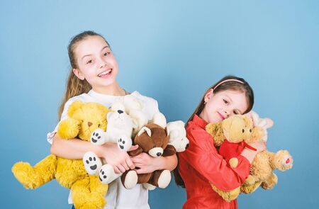 Family bonding. little sisters girls playing game in playroom. toy shop. childrens day. playground in kindergarten. happy childhood. handmade. sewing and diy crafts. small girls with soft bear toysの写真素材