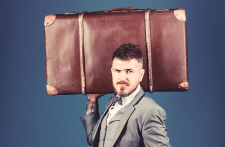 heavy bag. mature traveller. bearded man in formal suit. stylish esthete with vintage bag. businessman in bow tie. business trip with retro suitcase. Elegance and style. Trendy and handsomeの写真素材