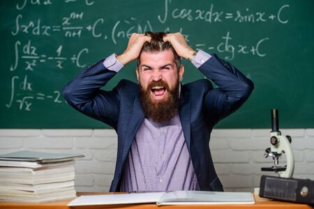 Difficult work. Emotional burnout. Teacher give up. Hate his job. Man desperate teacher in classroom. Going mad. Teaching dumb students. No hope for better. Tired and exhausted. Teacher mature manの写真素材