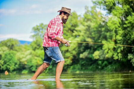 For me hobby is First. Successful fly fishing. summer weekend. fisherman show fishing technique use rod. experienced fisher in water. sport activity and hobby. man catching fish. man fly fishingの写真素材