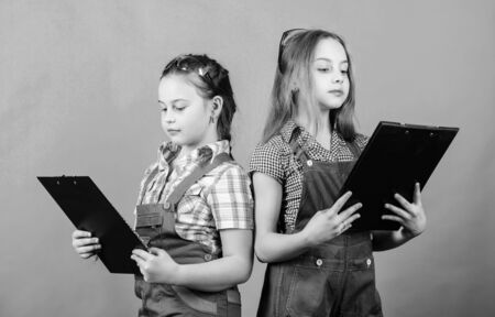 small girl repairing in workshop. Foreman inspector. Repair. Child care development. Safety expert. Future profession. Builder engineer architect. Kid worker with plan folder. Smart professionalの写真素材