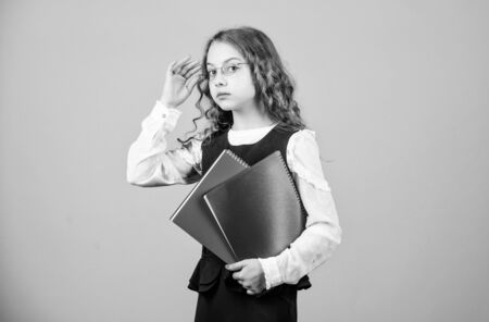 serious small girl wants to be teacher. hometwork. notebook for diary notes. study lesson. knowledge and education. Back to school. small girl with paper folder. Studying hard for good gradesの写真素材