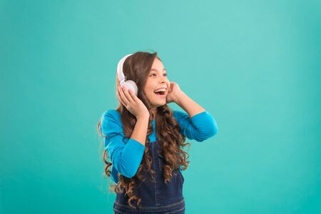 Music sounds better with my headphones. Little girl wearing headphones on blue background. Cute...