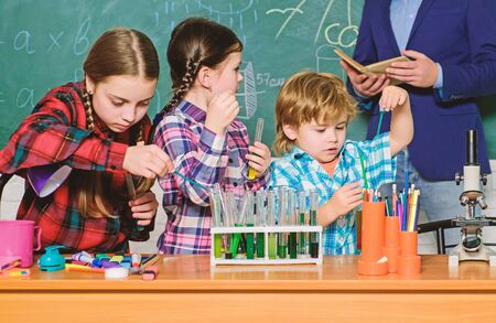 chemistry lab. back to school. happy children teacher. kids in lab coat learning chemistry in school laboratory. making experiment in lab or chemical cabinet. Testing blood samplesの写真素材