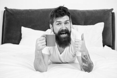 Great time at home. mature male with beard in pajama on bed. asleep and awake. energy and tiredness....