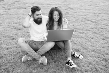 Modern technologies. Online work. Couple students green meadow. Laptop online communications....