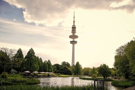 Sending and receiving waves. Tower or radio mast. TV tower on urban landscape. Tall tower supporting transmitting antenna. Tower structure for telecommunications and broadcastingの写真素材