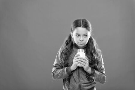 Take vitamin supplements. Complete multivitamin and mineral childrens formula. Girl hold medicines bottle. Vitamin concept. Child girl take medicines. Treatment and medicine. Need vitamin supplementsの写真素材
