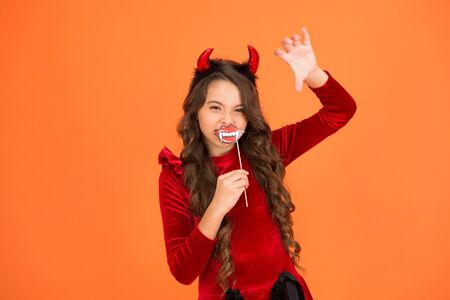 Halloween costumes. Photo booth props. Vampire teeth. Little girl cute small horns celebrate...