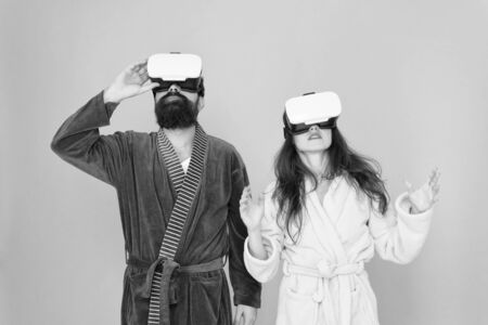 Looking upwards. Gaming and entertainment. Future closer than you think. Family explore VR at home. VR technology and future. VR communication. Exciting impressions. Couple bathrobes wear VR glasses.の写真素材