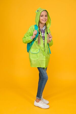 Waterproof cloak. Waterproof fabric for your comfort. Rainproof accessory. Schoolgirl hooded raincoat enjoy rainy weather. Waterproof clothes every kid should try. Kid girl happy wear raincoatの写真素材