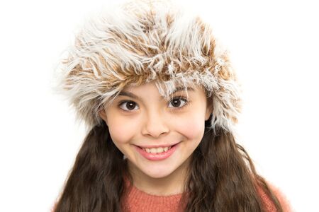 Fancy fur. Cozy winter outfit. Little kid wear hat. Stay warm this winter. Happy little girl in winter fashion. Small child smiling in fur hat white background. Cute model enjoy winter styleの写真素材